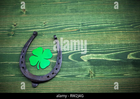 San Patrizio giorno, portafortuna sul verde sullo sfondo di legno Foto Stock