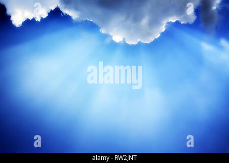 I raggi di luce dal sole attraversano le nuvole Foto Stock