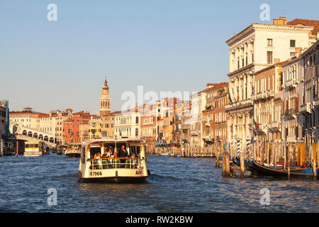 Il vaporetto vaporetto sul Canal Grande al tramonto, Venezia, Veneto, Italia con una vista ultimi palazzi antichi, palazzi, per il Ponte di Rialto Foto Stock