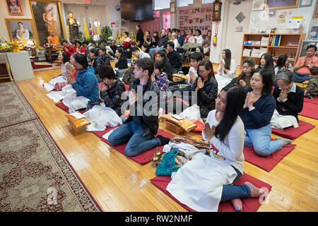 Per i fanatici buddisti, molti provenienti dalla Thailandia, pregare e meditare a un tempio nel Queens, a New York City Foto Stock