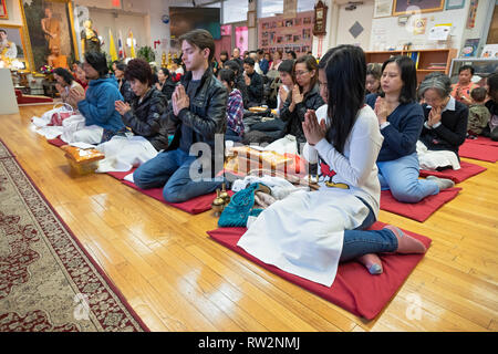 Per i fanatici buddisti, molti provenienti dalla Thailandia, pregare e meditare a un tempio nel Queens, a New York City Foto Stock