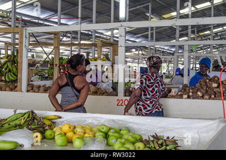 SCARBOROUGH, TRINIDAD E TOBAGO - 11 gennaio 2019: gli acquirenti che stanno curiosando i prodotti freschi in vendita presso il mercato coperto in Scarborough, Tobago. Foto Stock