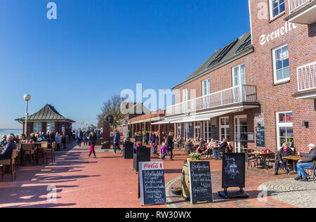 Le persone che si godono il sole in un cafe in Wilhelmshaven, Germania Foto Stock