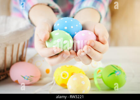 Felice Pasqua. Congratulazioni sfondo pasqua. Il bambino tiene le uova di Pasqua in mano. Messa a fuoco selettiva. Foto Stock