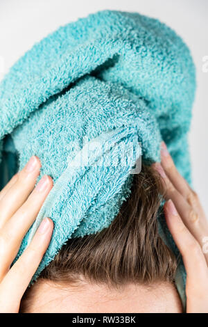 Essiccazione femmina i capelli con un asciugamano. Close-up di donna con asciugamano da bagno per il manuale di asciugatura dei capelli Foto Stock