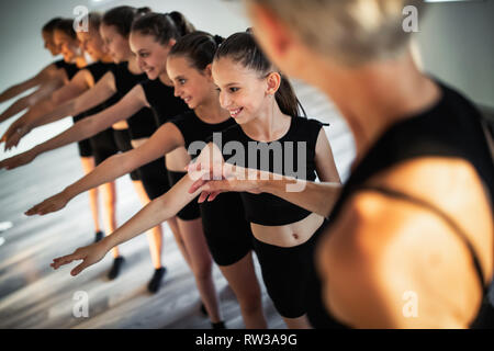 Insegnante e gruppo di bambini esercizio di danza e balletto in scuola di ballo Foto Stock