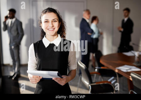 Vita Ritratto di Allegro giovane donna che guarda la fotocamera in piedi nella sala conferenze, spazio di copia Foto Stock