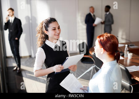 Angolo alto ritratto di due allegro imprenditrici chiacchierando durante la pausa nella sala conferenze, spazio di copia Foto Stock