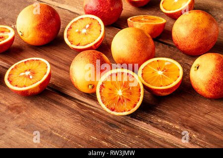 Organici freschi arance pigmentate al buio su un rustico sfondo di legno con spazio di copia Foto Stock