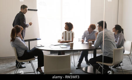 Imprenditore allenatore dando la presentazione su lavagna al team di formazione aziendale Foto Stock