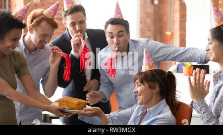 Dipendenti in sede di persone in parte cappelli congratulate happy collega femmina Foto Stock