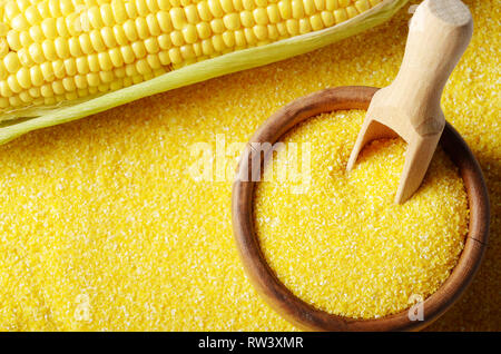 Vista dall'alto di Ripe fresche biologiche tutolo di mais dolce e ciotola di legno con convogliatore closeup su sfondo grits Foto Stock