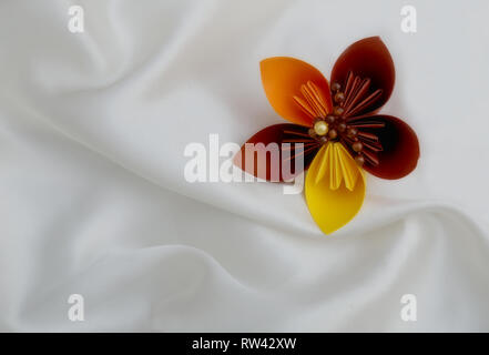 Un bellissimo origami flower su un bianco sullo sfondo di lusso Foto Stock