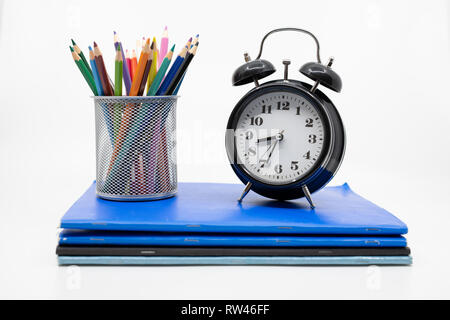 Tempo per il concetto di scuola con libri, matite e sveglia Foto Stock