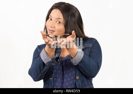 Ritratto di felice giovane donna che mostra e offrendo occhiali su sfondo bianco. Selezione del concetto di occhiali Foto Stock