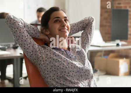 Trasognata felice imprenditrice indiano prendendo rilassante pausa di lavoro Foto Stock