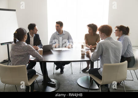 Imprenditori a discutere il progetto di business alla riunione multietnica in sala conferenze Foto Stock