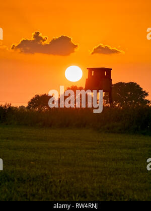 Tramonto dietro a nascondere nel Elbmarsch vicino Barum, Germania. Foto Stock