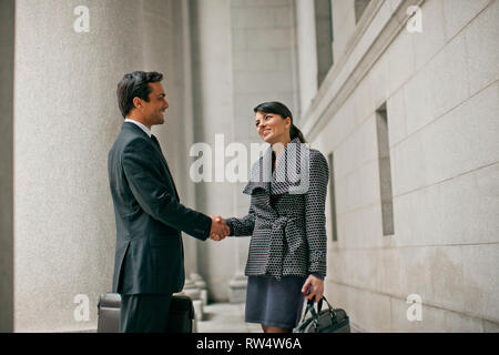 Imprenditrice sorridente e imprenditore agitare le mani. Foto Stock