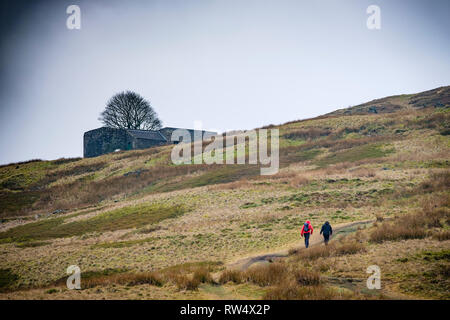 Walkers sul percorso verso la cima ambiti, Haworth Moor, West Yorkshire, Inghilterra. Foto Stock