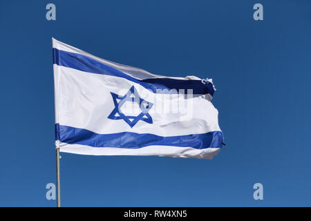 Il Magen David, stella di Davide - Israele il flag - onde in un vento forte contro un cielo blu. Foto Stock