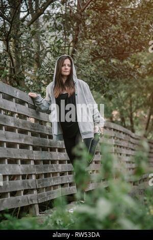 La donna lo stiramento in posizione di parcheggio Foto Stock