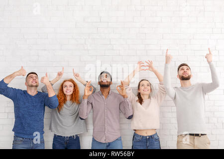 Diversi amici gesti con le mani sul muro bianco Foto Stock