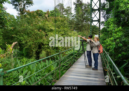 I turisti con la guida sul ponte sospeso a La Seva Stazione Biologica,foresta pluviale tropicale,Sarapiqui,Costa Rica,l'America centrale Foto Stock