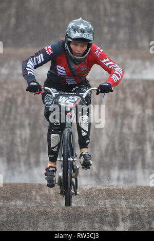 Pista di BMX racing. Rider in donne gara sprint evento. In condizioni difficili dal tempestoso vento e pioggia. Foto Stock