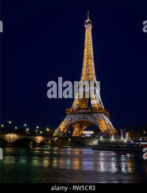 Alla Torre Eiffel, Parigi. Fotografato durante il suo magnifico display illuminazione, che si vede riflessa nel fiume Senna. Foto Stock