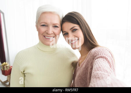 Senior madre e figlia tenendo selfie a casa Foto Stock