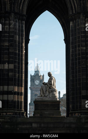 Vista attraverso il Monumento di Scott verso la torre dell orologio in background in una giornata di sole, Edimburgo, Scozia Foto Stock