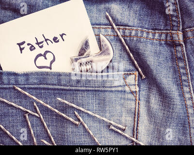 Nota carta con la parola padre e dipinta con un cuore sullo sfondo di una tasca dei jeans. Close-up, vista dall'alto. Bella carta per il vostro amato fath Foto Stock