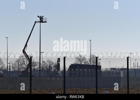 Street light maintenance - un ingegnere elettrico svolge il suo lavoro su strada lighing in altezza utilizzando un cherry picker Foto Stock