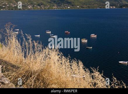 Il lago di Ohrid con barche da pesca e la gamma della montagna in background in inizio autunno, Macedonia, Europa orientale Foto Stock