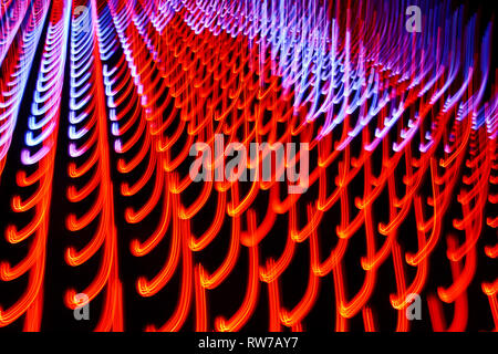 Abstract rosso-arancio e blu-viola i modelli luminosi in movimento su sfondo scuro. Primo piano la foto in orizzontale. Foto Stock