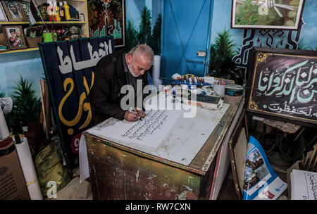 La striscia di Gaza, la Palestina. 30 gen, 2019. Hashim Klob, 59, è un artista Palestinese che ha sostenuto la sua famiglia come un pittore e calligrafo per più di 38 anni nel suo laboratorio privato di Gaza City, dove scrive tutto il Corano e opere su carta, legno e lamiera. Credito: Yousef Masoud/Pacific Press/Alamy Live News Foto Stock