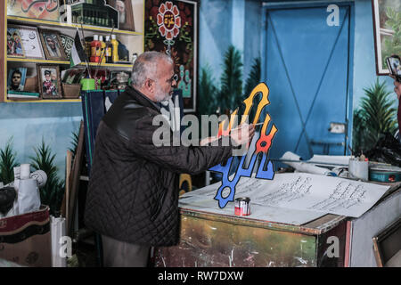 La striscia di Gaza, la Palestina. 30 gen, 2019. Hashim Klob, 59, è un artista Palestinese che ha sostenuto la sua famiglia come un pittore e calligrafo per più di 38 anni nel suo laboratorio privato di Gaza City, dove scrive tutto il Corano e opere su carta, legno e lamiera. Credito: Yousef Masoud/Pacific Press/Alamy Live News Foto Stock