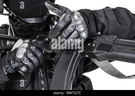 Spec Ops soldato in uniforme nera e la maschera per il viso con il suo fucile. Foto Stock