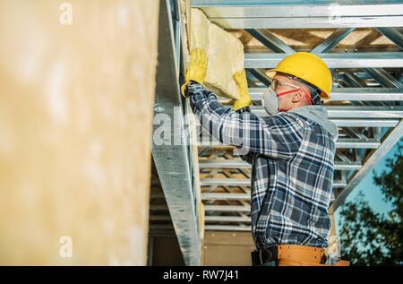 Parete di isolamento mediante installazione costruzione professionale Lavoratore. La lana minerale isolante della casa. Foto Stock