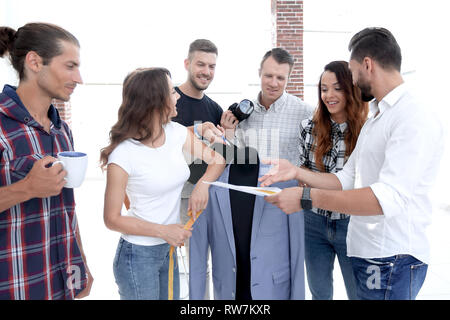 Progettisti che lavorano con i nuovi modelli di abbigliamento uomo Foto Stock