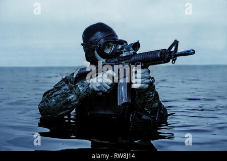 Navy Frogman tenuta con attrezzatura completa e armi nell'acqua. Foto Stock