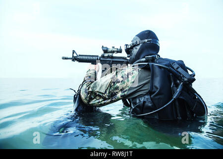 Navy Frogman tenuta con attrezzatura completa e armi nell'acqua. Foto Stock