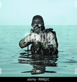 Navy Frogman tenuta con attrezzatura completa e armi nell'acqua. Foto Stock