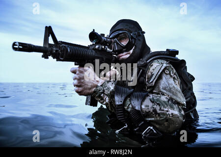 Navy Frogman tenuta con attrezzatura completa e armi nell'acqua. Foto Stock