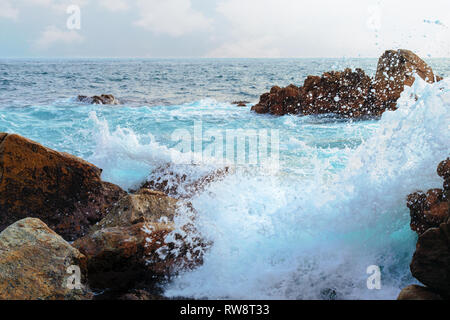 Paesaggio marino, onde e rocce. Onde tempestose a schiantarsi sulla roccia. La schiuma delle onde. Spruzzi di acqua dell'oceano. Foto Stock