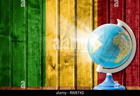 Globo con una mappa del mondo su un sfondo di legno con l'immagine della bandiera del Mali. Il concetto di viaggio e il tempo libero all'estero. Foto Stock