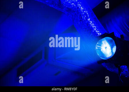 Blu brillante luce presso il garage sotterraneo con tubi di ventilazione a sfondo Foto Stock