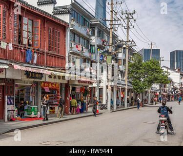 Una street view nella Vecchia Shanghai. Servizio lavanderia appeso fuori ad asciugare sulla finestra binari delle vecchie case, dietro le quali la Shanghai Tower si alza. Cina. Foto Stock