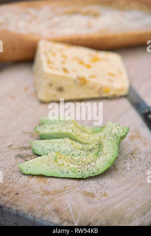 Fette di avocado su un scheda di pane con formaggio e baguette. Regno Unito Foto Stock